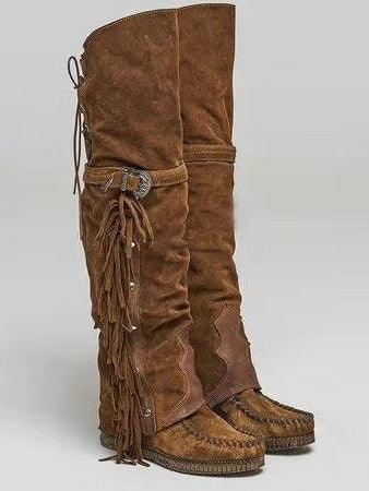 Botas altas planas de mujer con tachuelas y borlas por encima de la rodilla