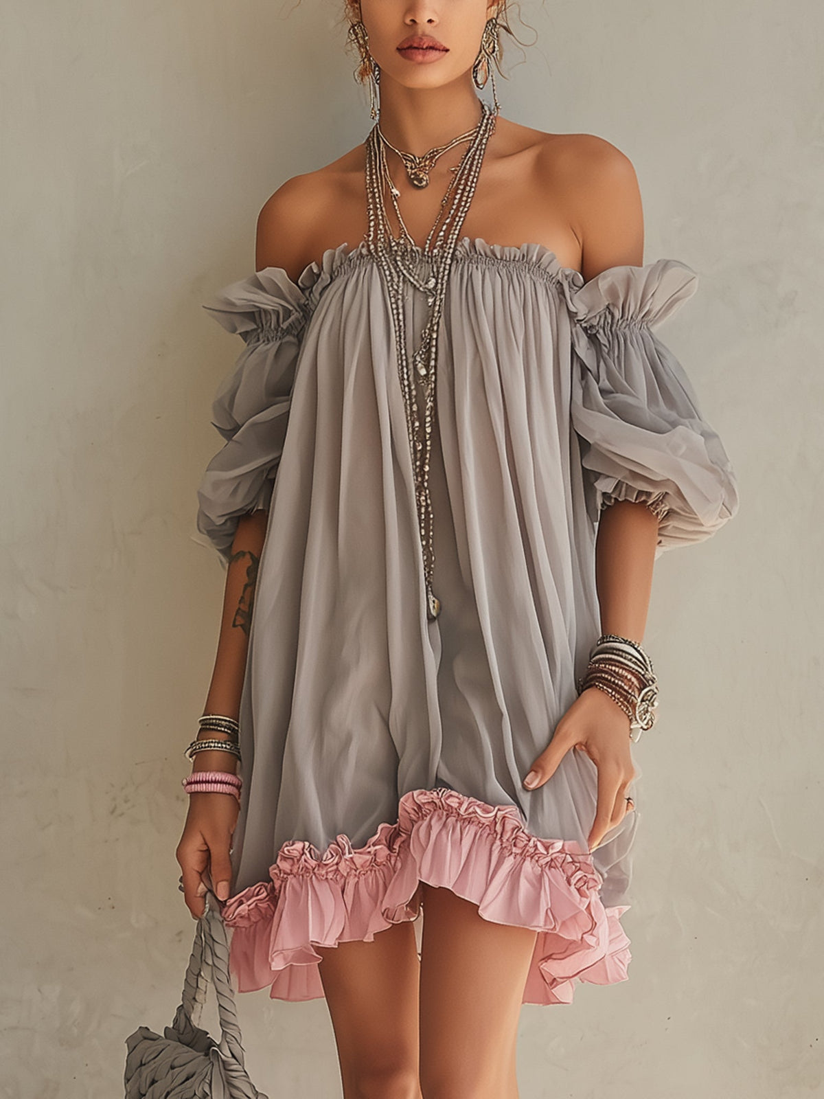 Vestido mini gris de gasa con hombros descubiertos y dobladillo rosa