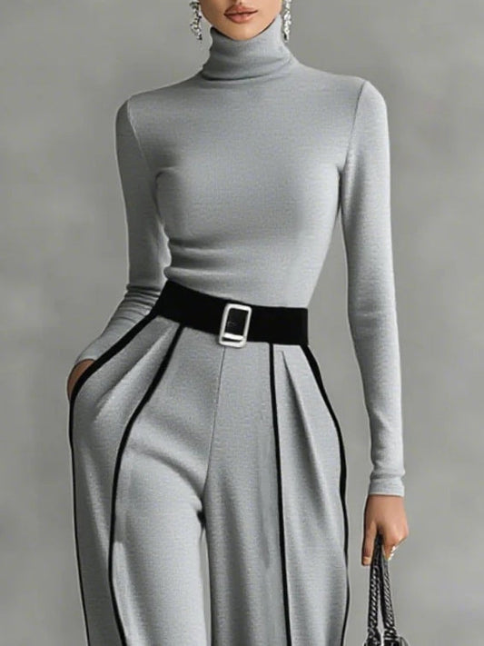 Conjunto de top gris con cuello alto y mangas largas, pantalones de pierna ancha y cinturón